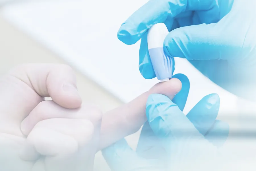 A doctor's gloved hand pricks a patients finger with to measure blood sugar, symbolizing diabetes treatment from Shelley Cole, M.D. of Healthy Success in Temple, Texas.