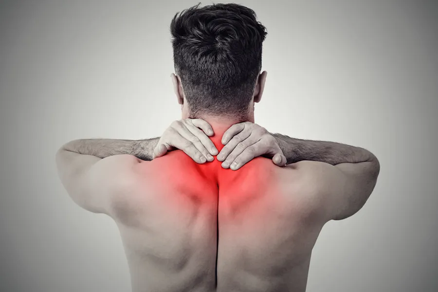 An image from behind of a man suffering from Fibromyalgia rubbing an area illustrated red with pain in his shoulders and neck . Get fibromyalgia treatment from Shelley Cole, M.D. of Healthy Success in Temple, Texas.