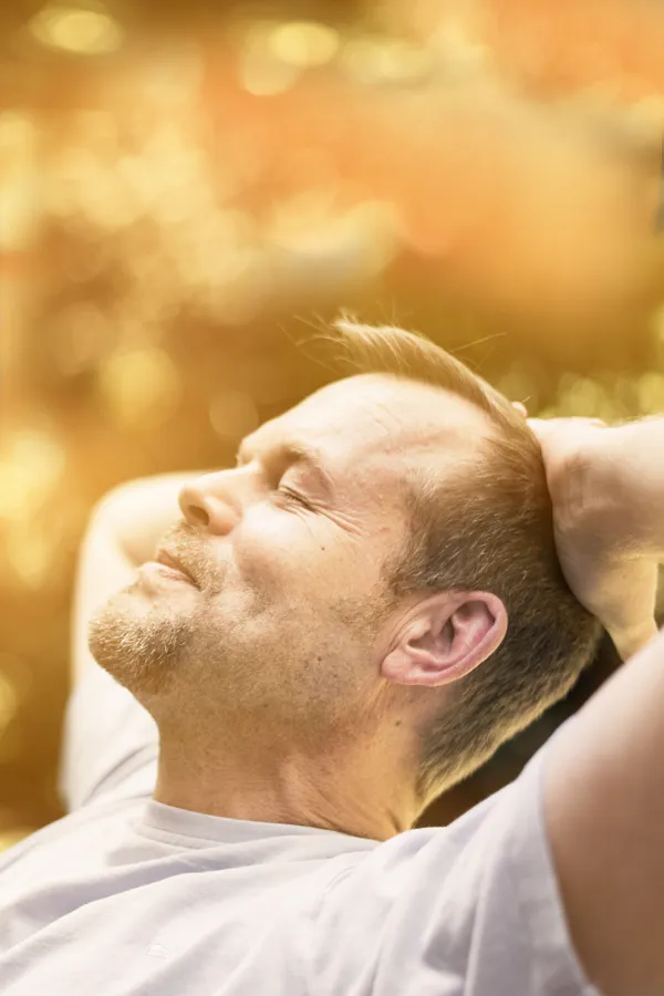 A man relaxes in the sun. Get red light therapy from Shelley Cole, M.D. of Healthy Success in Temple, Texas.