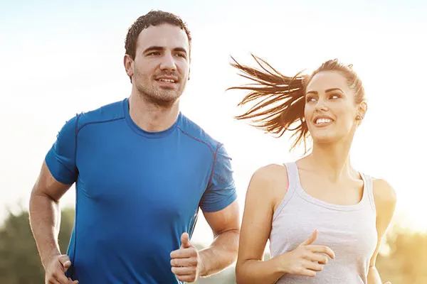 A couple happily jogging in the sunlight after receiving effective weight loss resistance care from Shelley Cole, M.D. of Healthy Success in Temple, Texas.